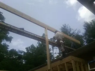 Carpenter setting a ridge beam over a new addition frame — Ice Dam Removal by Roofing Brothers in Minneota