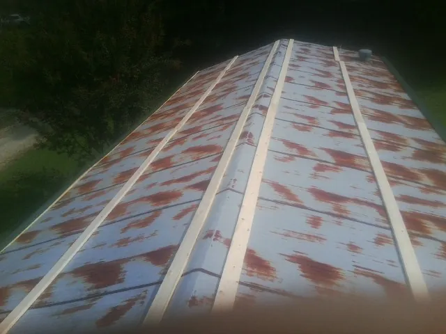 Rusted metal roof panels with new wood purlins before replacement — Storm Damage Roof Repair in Minneota by Roofing Brothers