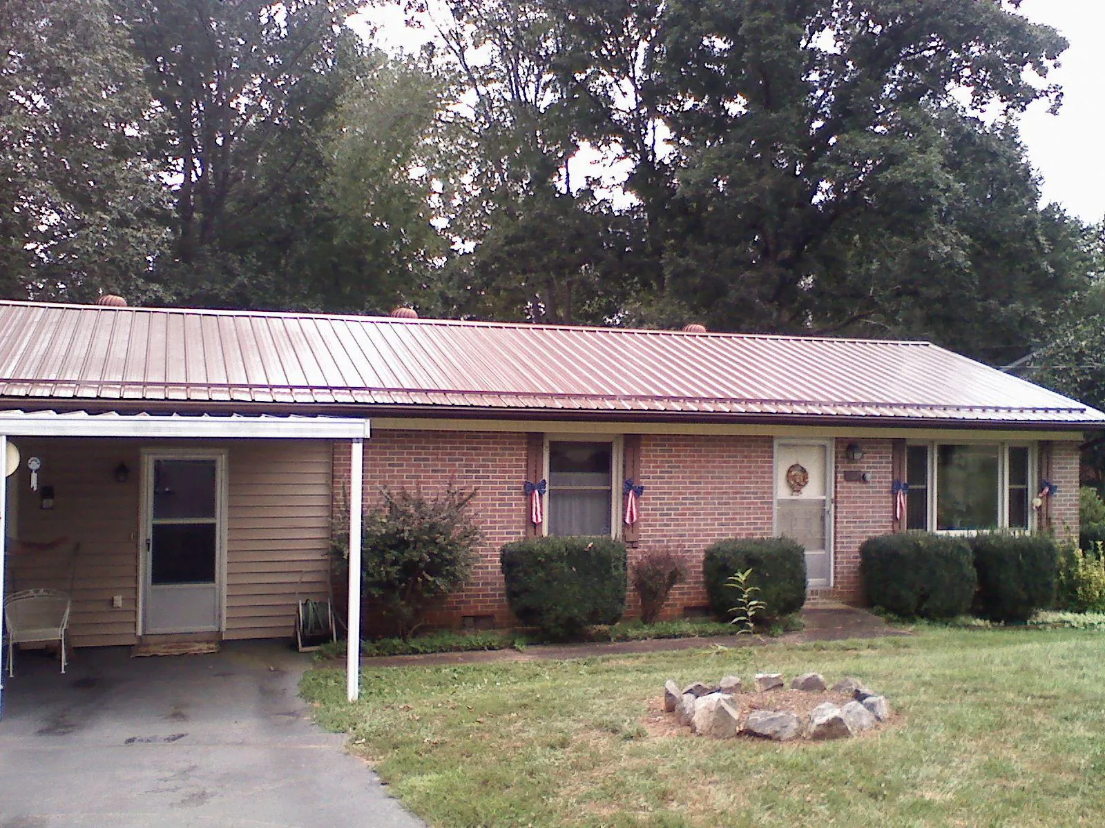 Bronze metal roof and carport on a brick ranch home — Roof Repair work by our crew in Minneota